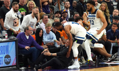 Apr 28, 2024; Phoenix, Arizona, USA; Minnesota Timberwolves guard Mike Conley (10) and Minnesota Timberwolves center Karl-Anthony Towns (32) tend to head coach Chris Finch after he was injured during the second half of game four of the first round for the 2024 NBA playoffs against the Phoenix Suns at Footprint Center. Mandatory Credit: Joe Camporeale-USA TODAY Sports