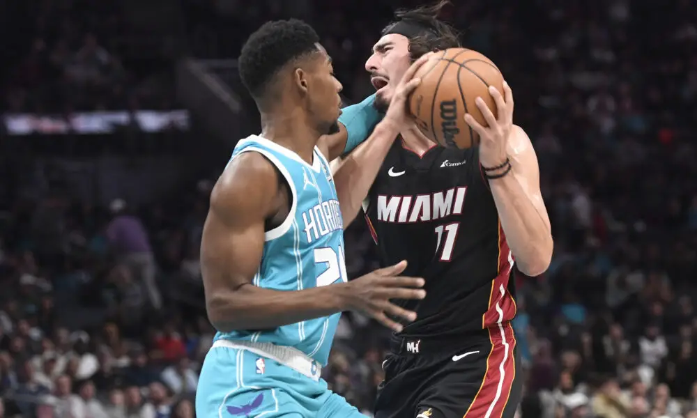 Dec 11, 2023; Charlotte, North Carolina, USA; Miami Heat forward Jaime Jaquez Jr. (11) drives into Charlotte Hornets forward guard Brandon Miller (24) during the first half at the Spectrum Center. Mandatory Credit: Sam Sharpe-USA TODAY Sports