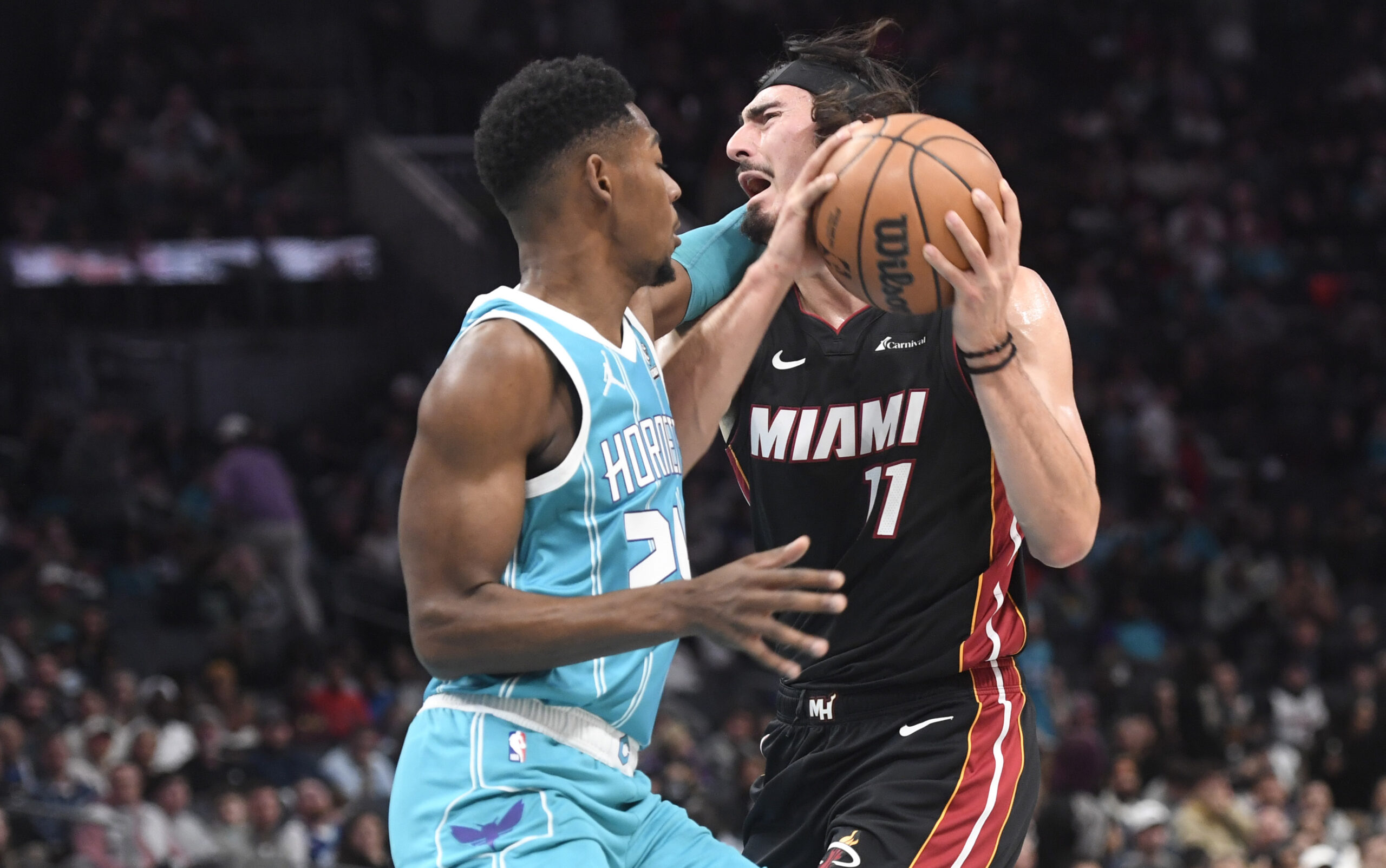 Dec 11, 2023; Charlotte, North Carolina, USA; Miami Heat forward Jaime Jaquez Jr. (11) drives into Charlotte Hornets forward guard Brandon Miller (24) during the first half at the Spectrum Center. Mandatory Credit: Sam Sharpe-USA TODAY Sports