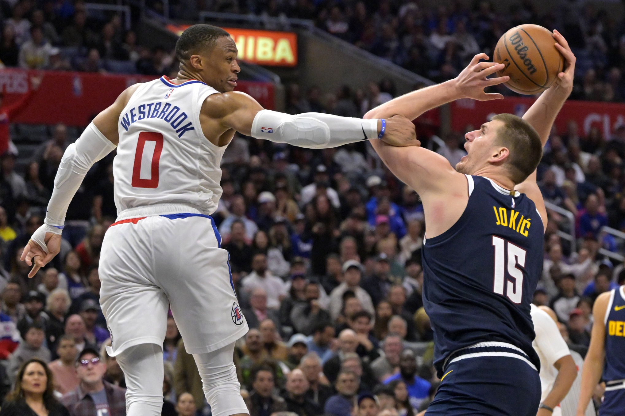 Apr 4, 2024; Los Angeles, California, USA; Denver Nuggets center Nikola Jokic (15) is fouled by Los Angeles Clippers guard Russell Westbrook (0) in the second half at Crypto.com Arena. Mandatory Credit: Jayne Kamin-Oncea-USA TODAY Sports